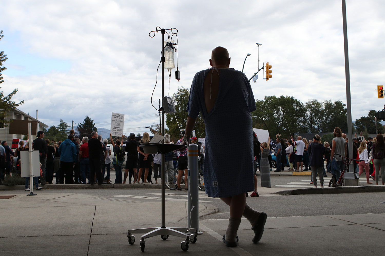 A Kelowna General Hospital patient watches a protest against COVID-19 health measures unfold outside of the hospital on Sept. 1, 2021. After the announcement of a provincial vaccine passport, at least 1,000 people took to the streets in front of the hospital to protest the program. (Photo by Aaron Hemens for Kelowna Capital News)
