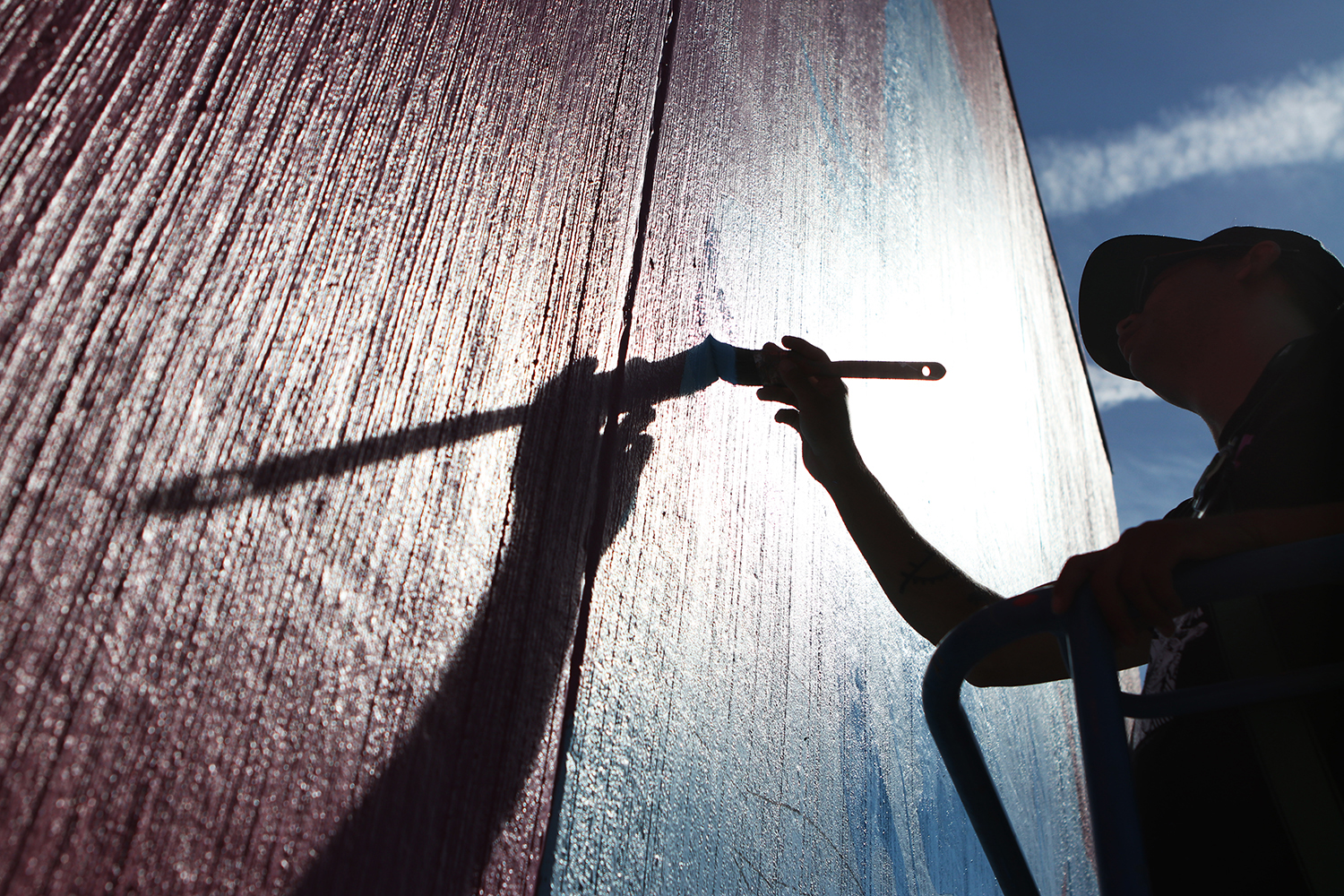 Sheldon Pierre Louis, a syilx visual artist, works on mural outside of the Gospel Mission shelter in Kelowna, B.C., on Sept. 7, 2021. (Photo by Aaron Hemens for Kelowna Capital News)