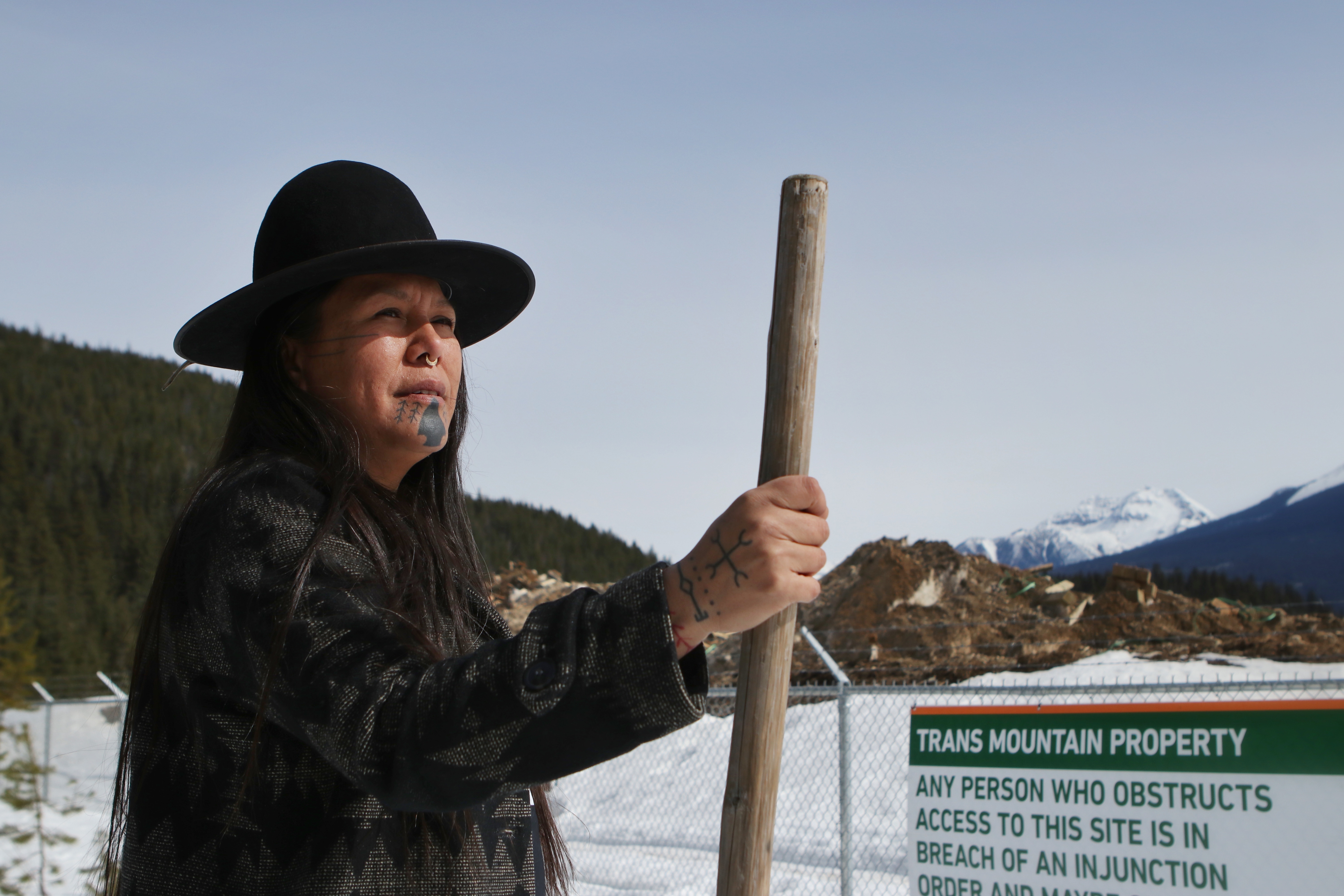 Kanahus Manuel, a member of the Tiny House Warriors, stands outside of the perimeter of a camp that houses 550 Trans Mountain Pipeline workers in Blue River, B.C., Canada, on April 14, 2022. Manuel is an inhabitant of the Tiny House Warriors village, which is located right beside the camp.
