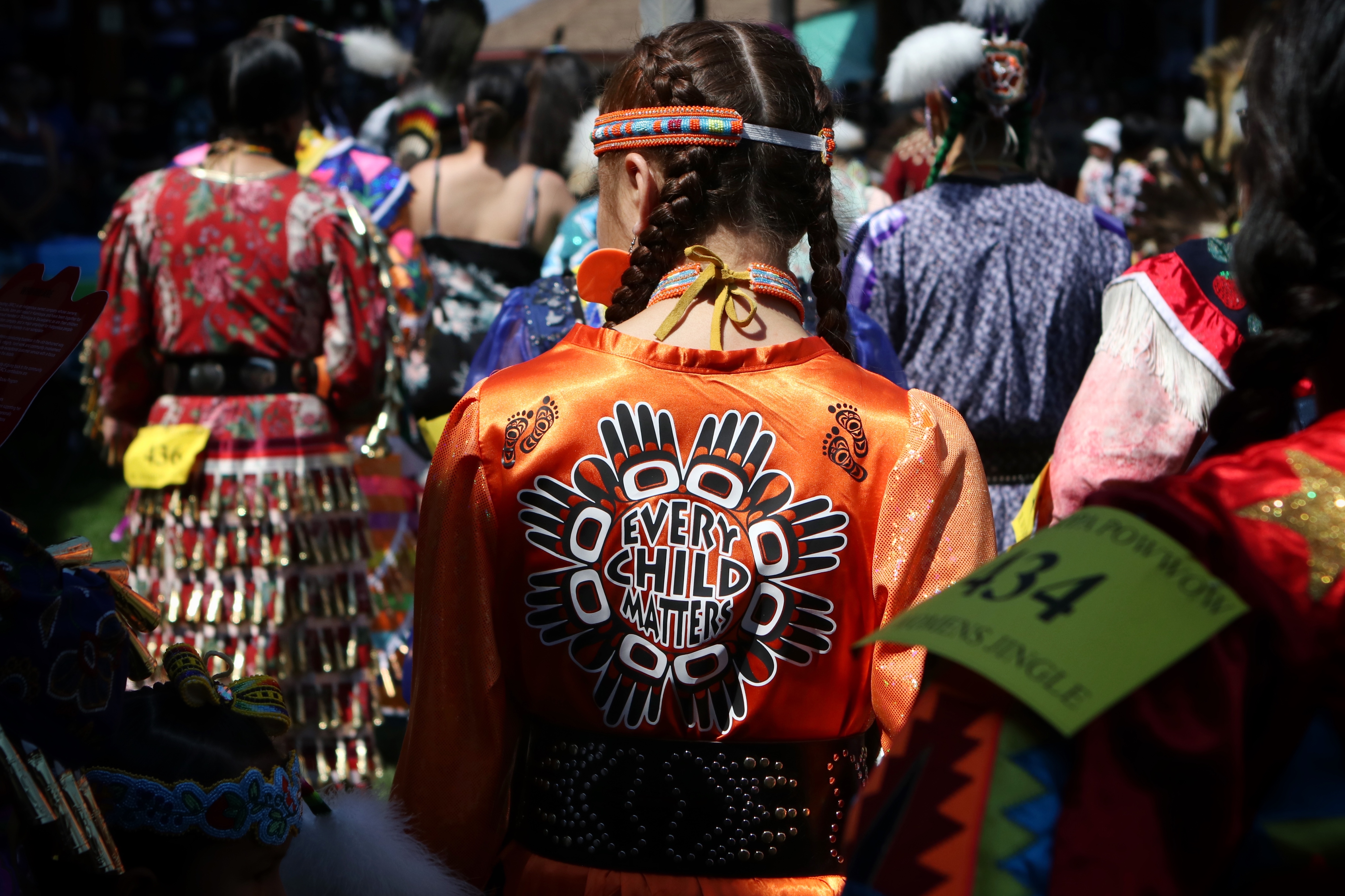 A dancer wearing regalia with “Every Child Matters” written on it participates in the grand entry of the second day of the 41st Kamloopa Powwow in Tk’emlúps (Kamloops) in Secwépemc homelands on July 30. (Photo by Aaron Hemens for IndigiNews)