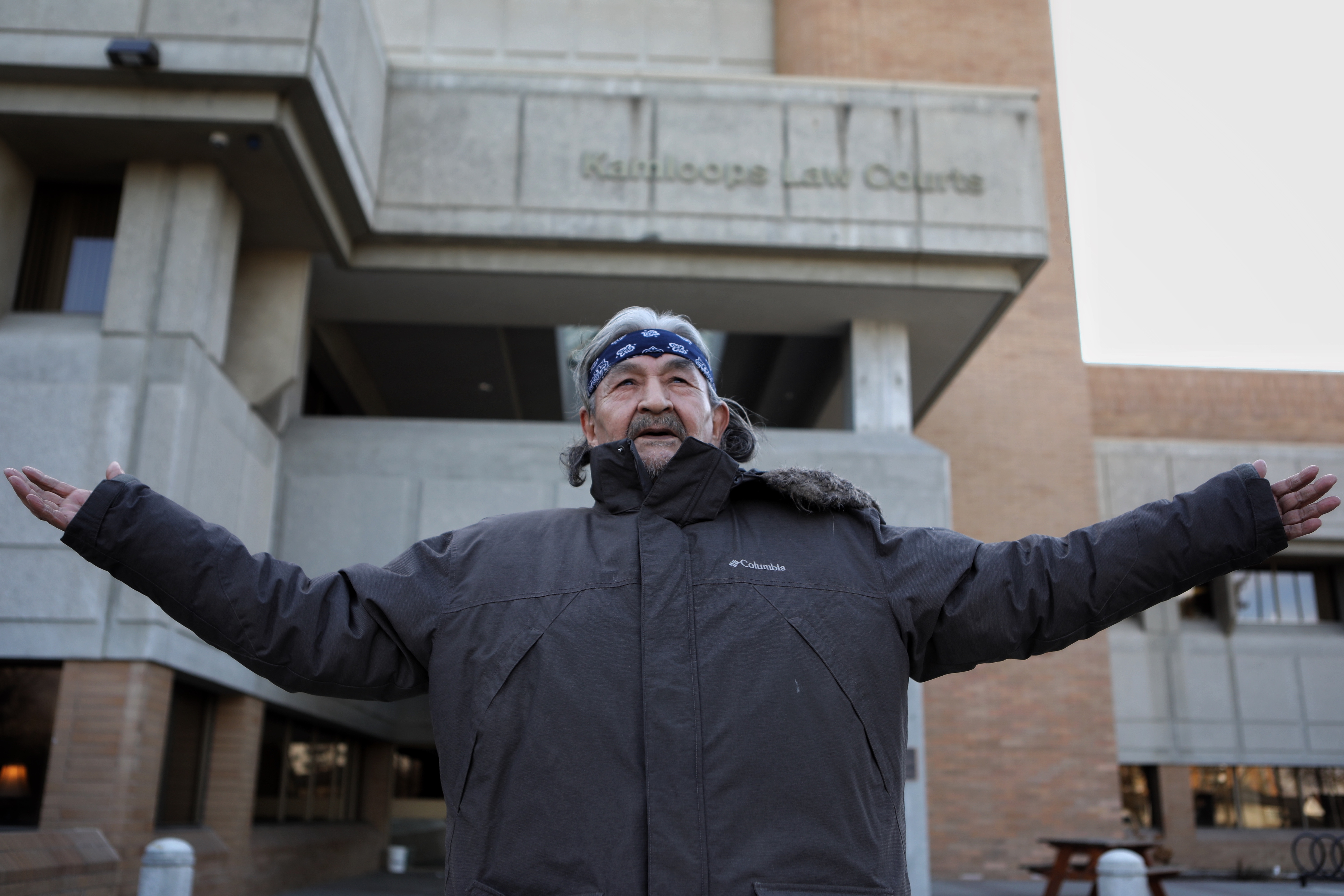 Secwépemc Hereditary Chief Saw-ses stands outside of Tkʼemlúps (Kamloops) courthouse in Secwepemcúl’ecw during the first day of his sentencing on Feb. 23, 2023. Saw-ses, a survivor of the Kamloops Indian Residential School, was sentenced to 28 days in jail for resisting Trans Mountain’s construction in his homelands. Photo by Aaron Hemens for IndigiNews